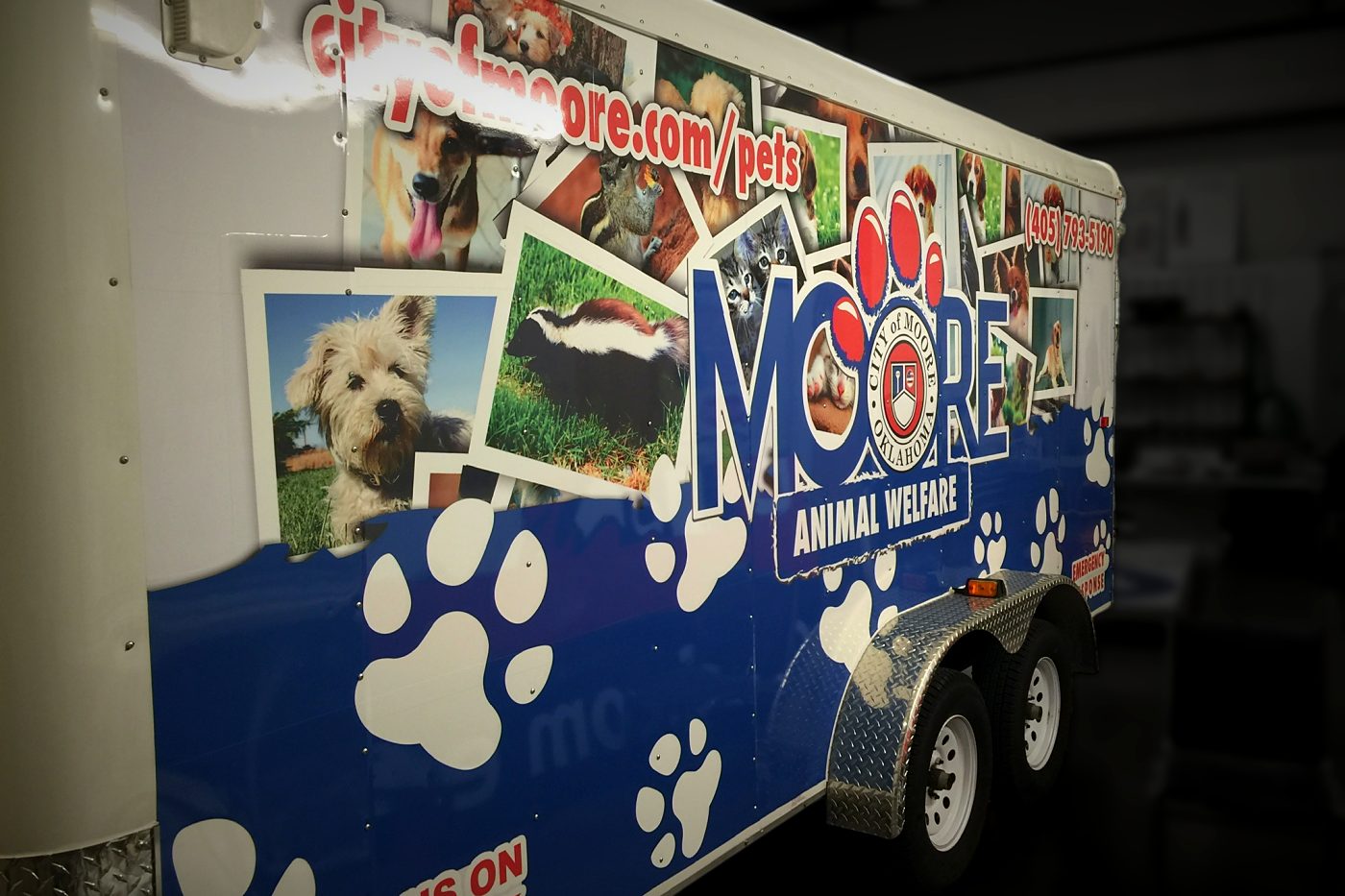 City of Moore Animal Welfare enclosed trailer wrap with pet photos and paw prints