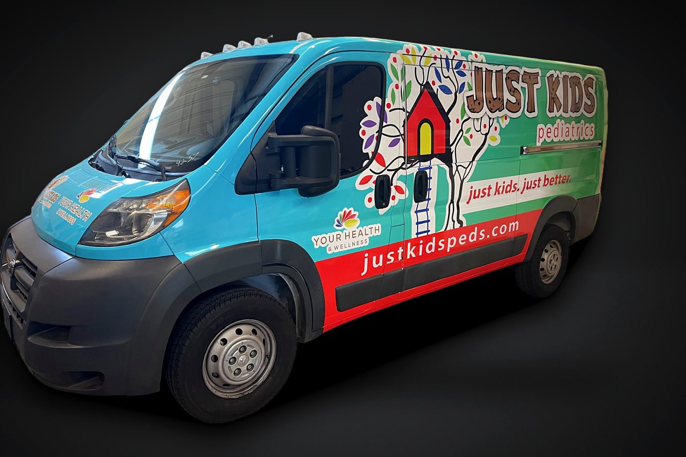 Just Kids Pediatrics full wrap on a Ram ProMaster van, front 3/4 view