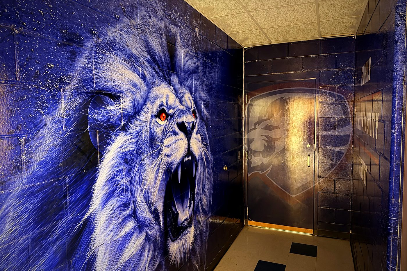 Moore High School lion wall wrap beside the locker room doorway