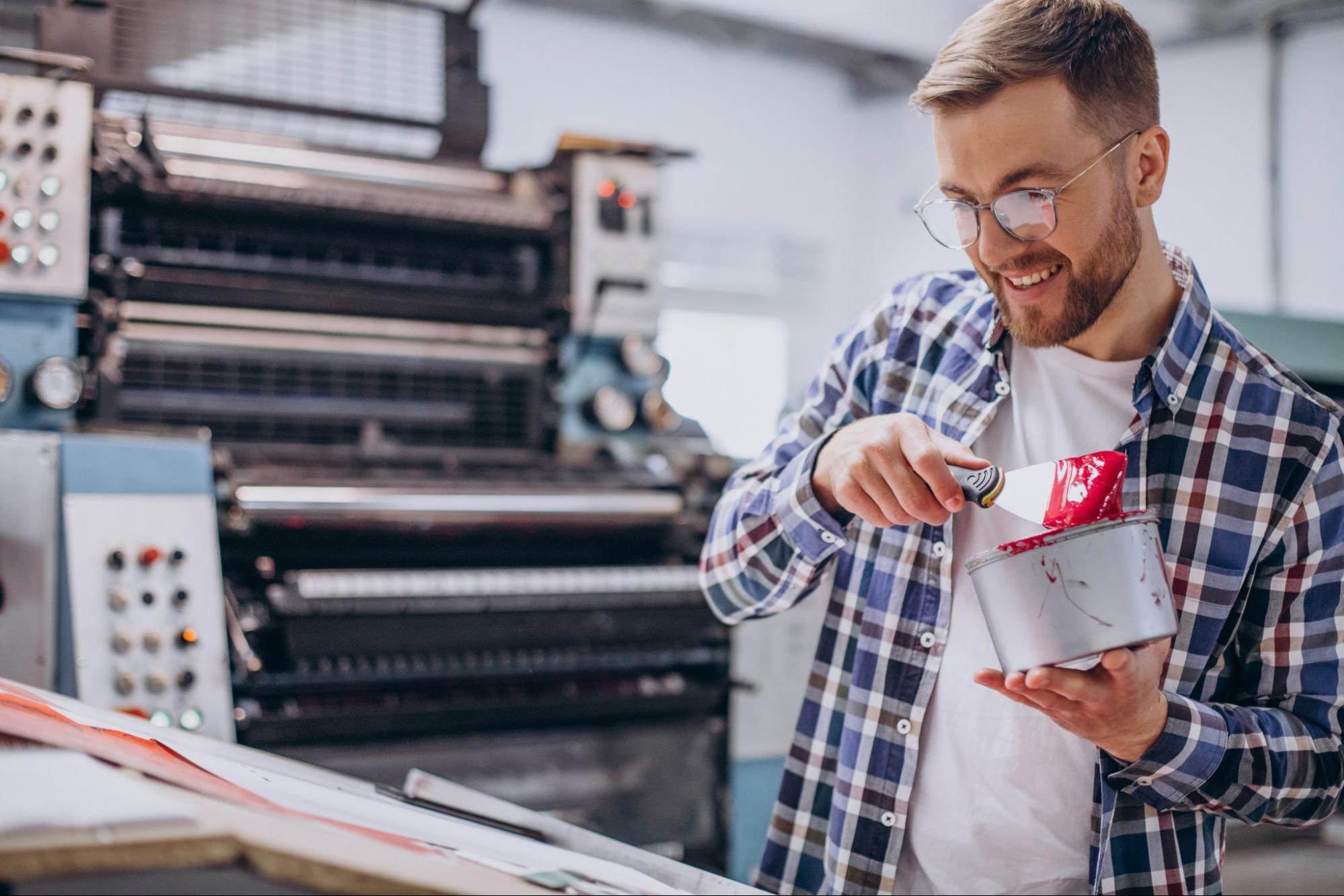 Print shop worker mixing ink
